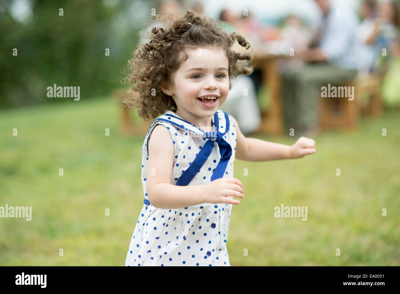 Junges Mädchen laufen und spielen bei Familientreffen Stockfoto