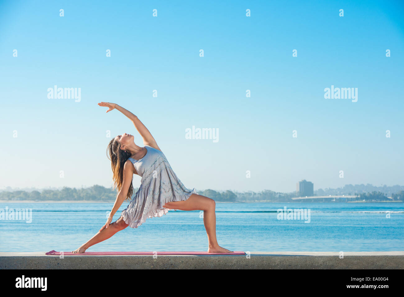 Junge Frau praktizieren Yoga am Pier in Pacific Beach, San Diego, Kalifornien, USA Stockfoto