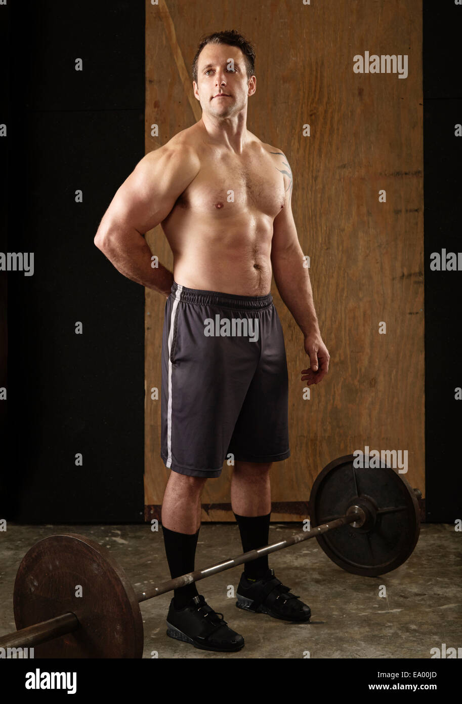 Porträt von muskulösen Mitte erwachsenen männlichen Gewichtheber mit Langhantel in Turnhalle Stockfoto
