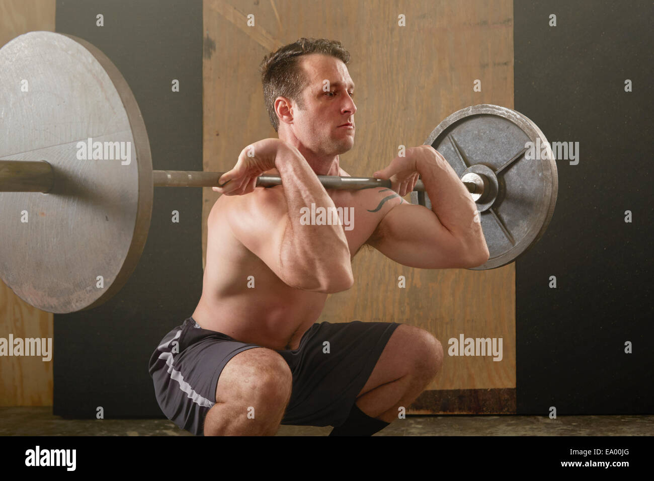 Mitte erwachsenen männlichen Gewichtheber heben Langhantel im Fitness-Studio Stockfoto