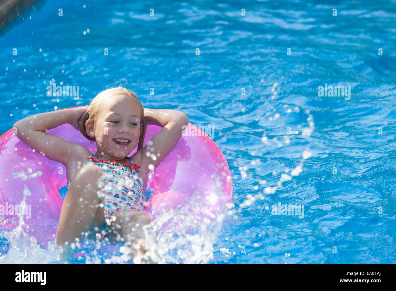 Mädchen liegend auf dem Rücken auf aufblasbaren Ring im Garten Schwimmbad Stockfoto