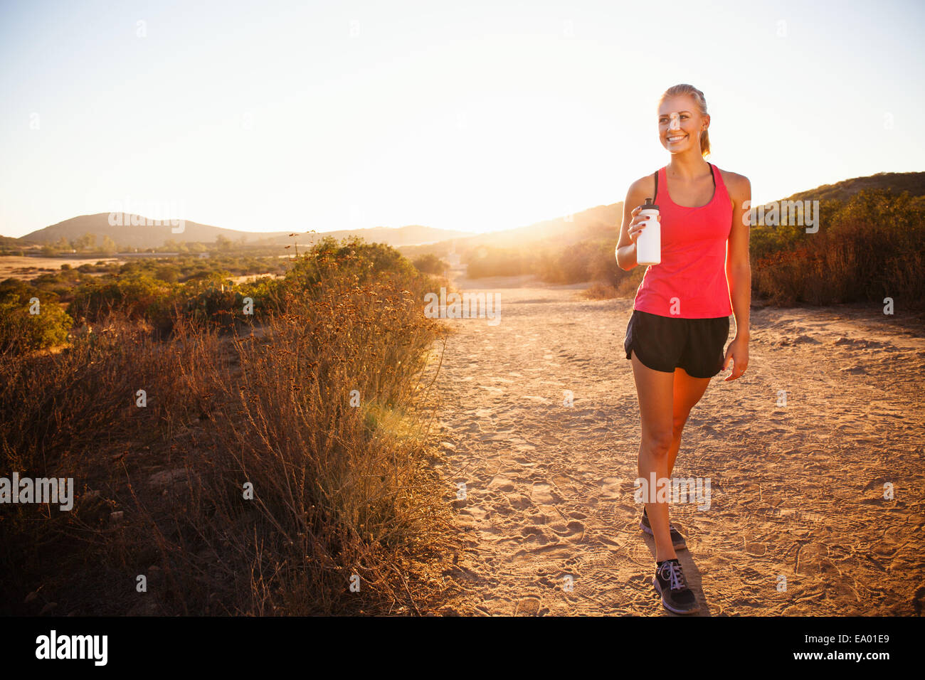 Weibliche Jogger Wasserflasche festhalten Weg, Poway, Kalifornien, USA Stockfoto