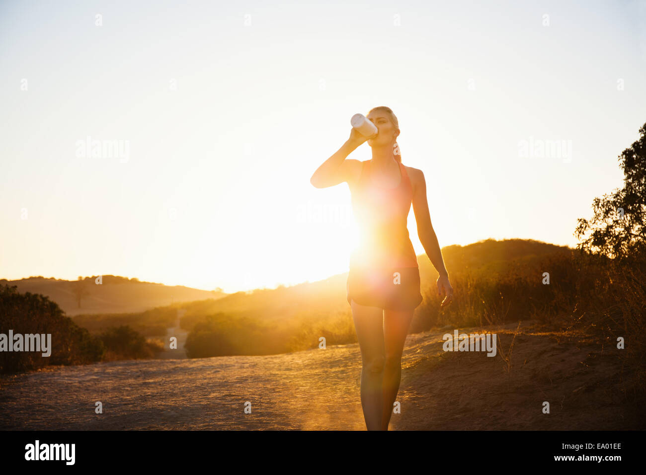 Weibliche Jogger trinken im Sonnenlicht, Poway, Kalifornien, USA Stockfoto