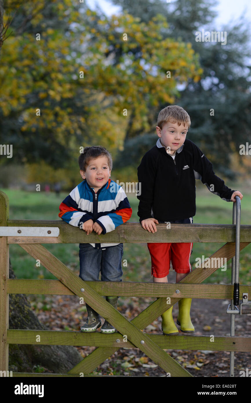 Zwei glückliche Kinder jungen Klettern am Holztor Uk Stockfoto