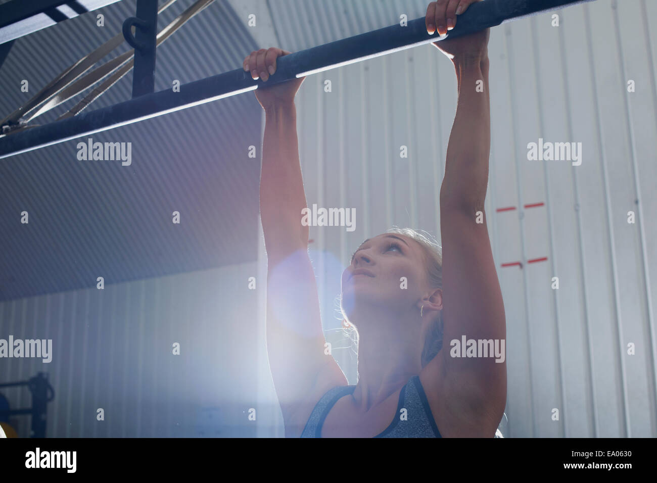 Frau tut Pull ups im Fitness-Studio Stockfoto