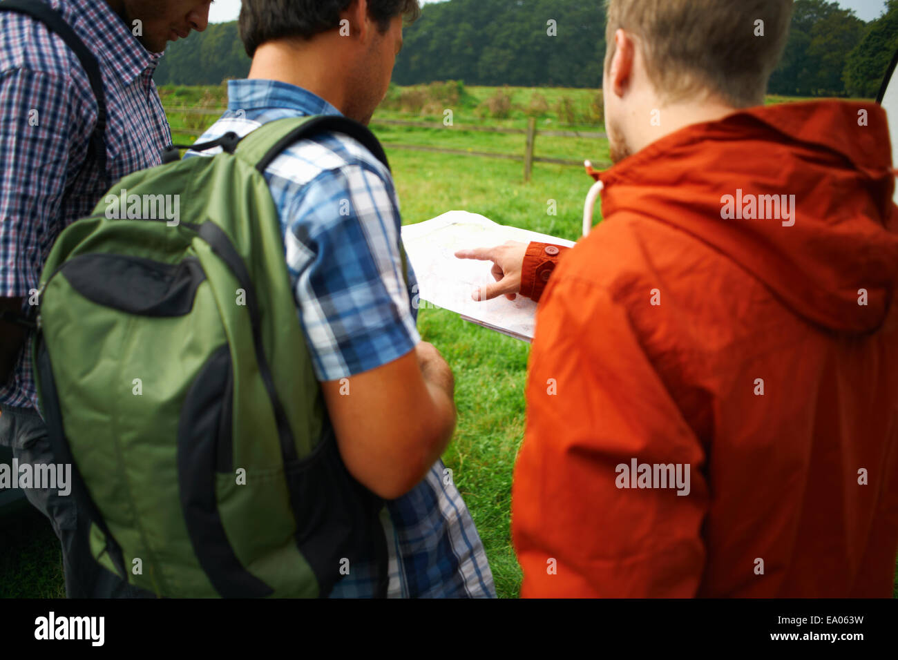 Drei Männer auf der Suche auf Karte Stockfoto
