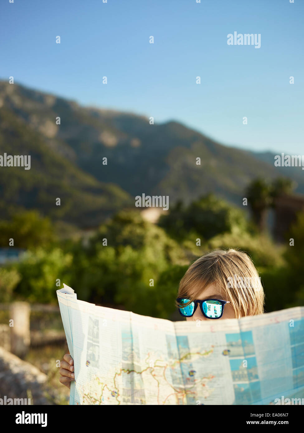 Junge in Sonnenbrille Blick auf eine Karte, Mallorca, Spanien Stockfoto