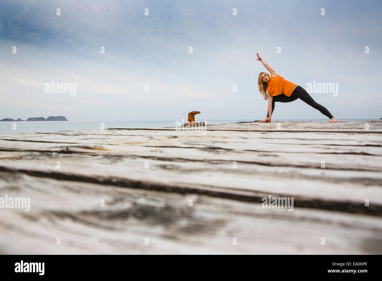 Mitte Erwachsene Frau üben Yogaposition auf hölzernen See pier Stockfoto