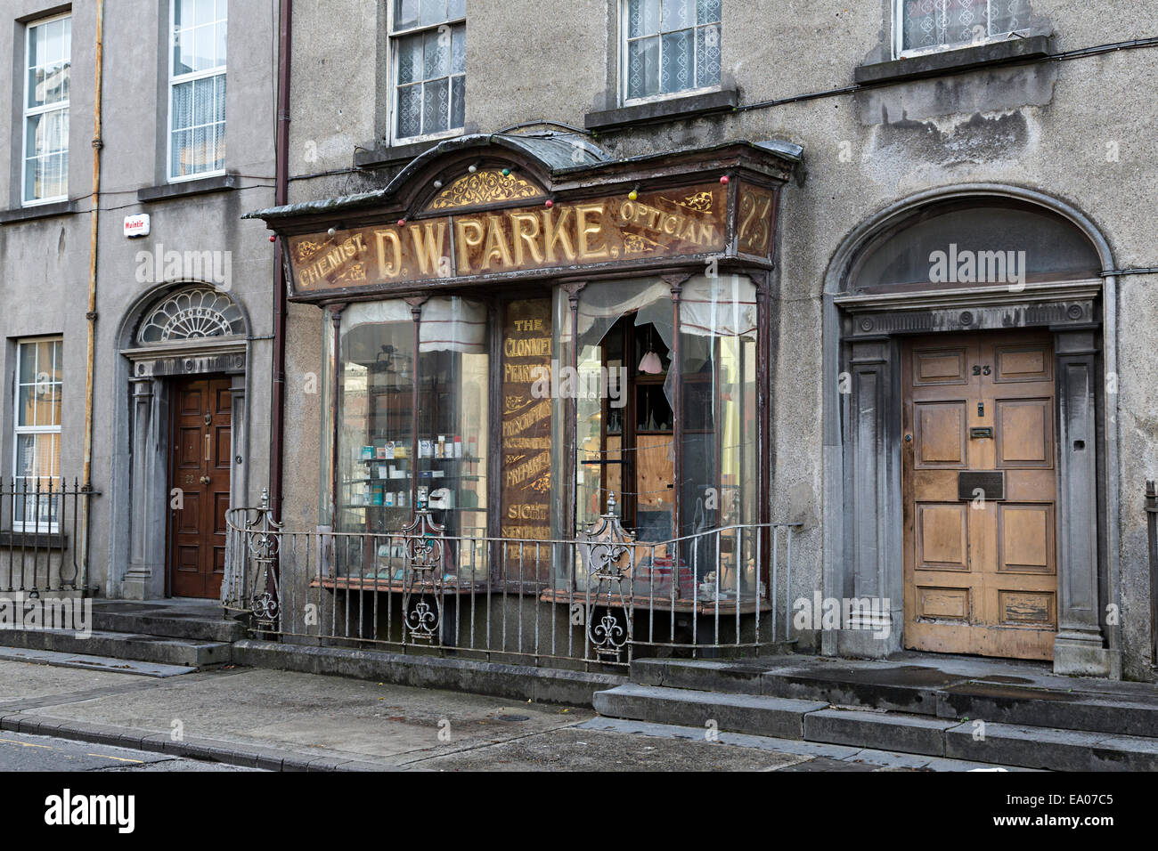 Alte Apotheke und Optiker Geschäft geschlossen jetzt in Straße in Clonmel, Irland Stockfoto