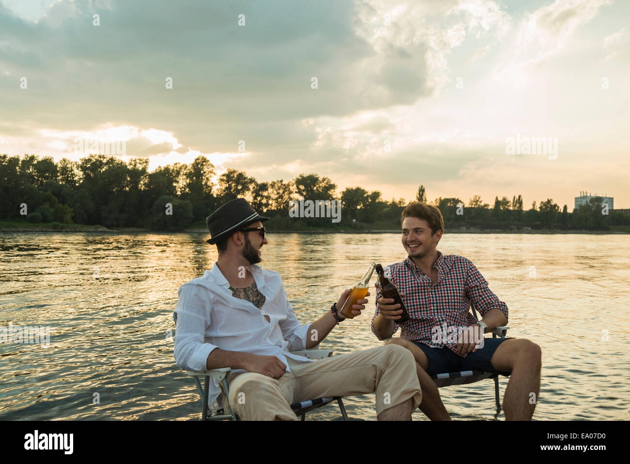 Junge Männer mit Bierflaschen See Toasten Stockfoto