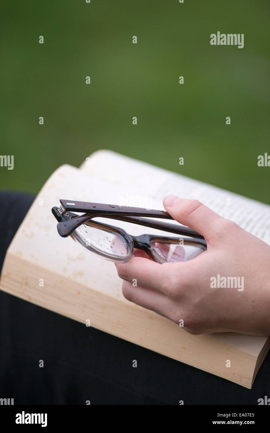 Hand mit Brillen halten Buch öffnen Stockfoto