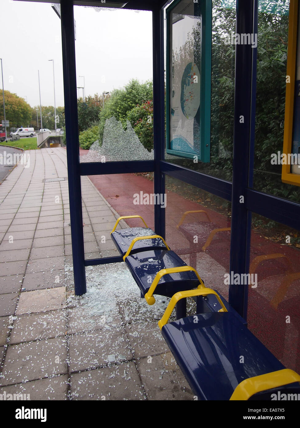 Eine städtische Wartehäuschen mit einem zerbrochenen Fenster und Glas auf dem Boden herum liegen Stockfoto