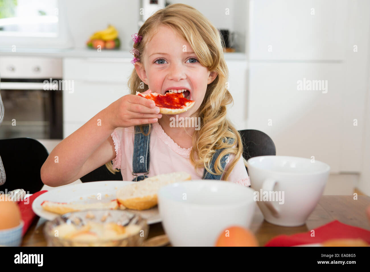 Mädchen Essen am Küchentisch Stockfoto