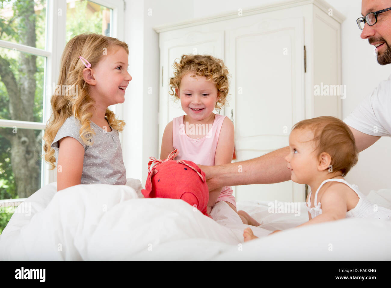 Drei Mädchen spielen auf Bett Stockfoto