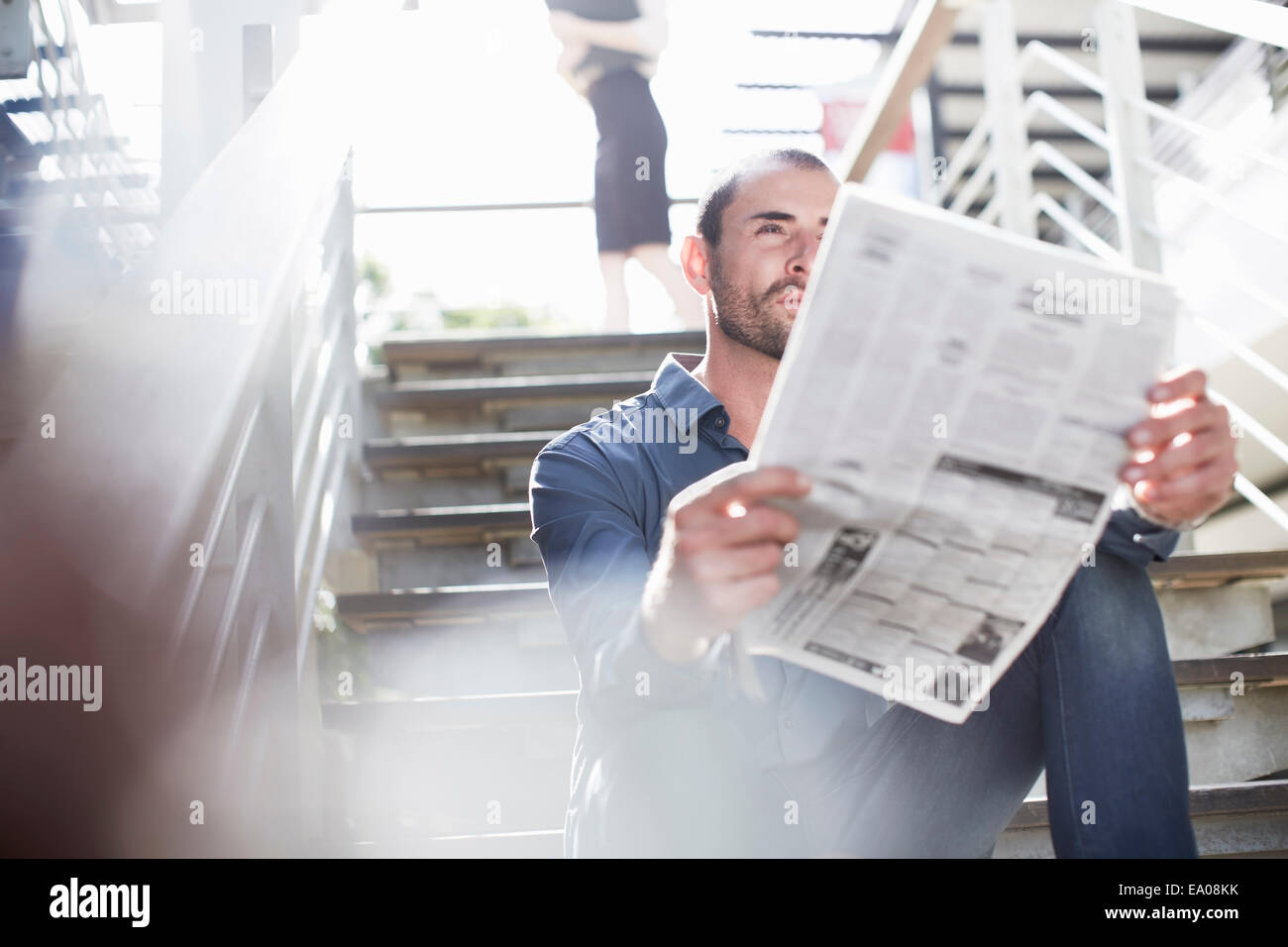 Geschäftsmann lesen Zeitungen auf Treppe Stockfoto