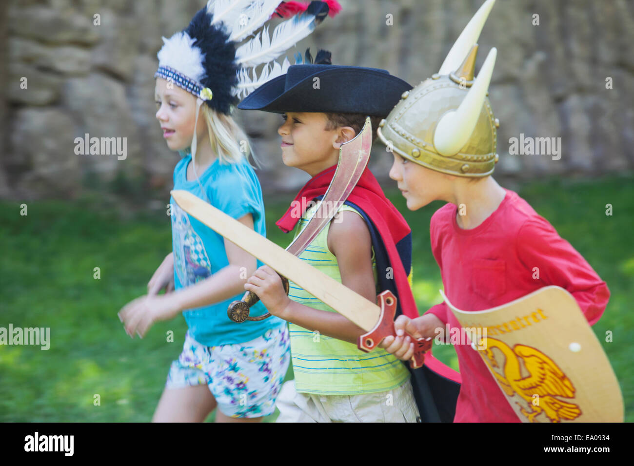 Drei Kinder tragen Fancy Dress Kostüme, spielen im park Stockfoto