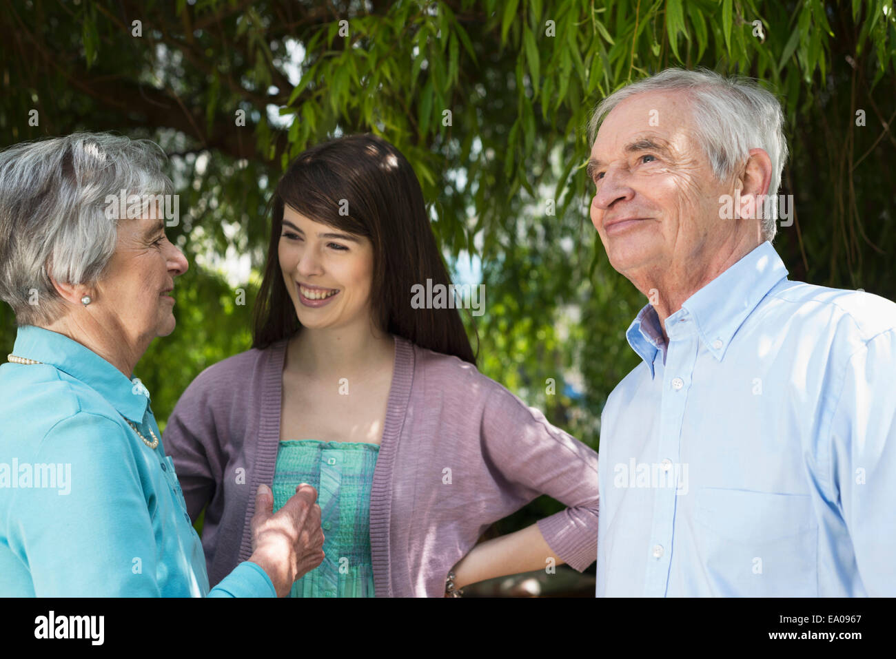 Großeltern und Enkeltochter, Gespräch im Garten Stockfoto