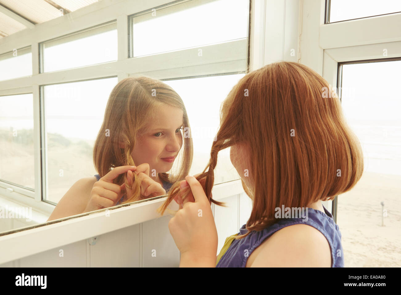 Mädchen Flechten Haar im Urlaub Wohnung Veranda Stockfoto