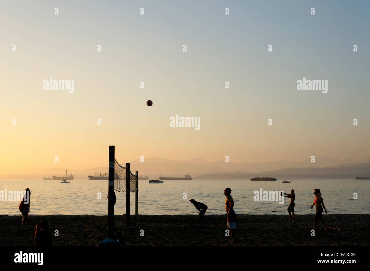Menschen Sie spielen Beach-Volleyball bei Sonnenuntergang, Kitsilano Beach, Vancouver, Britisch-Kolumbien, Kanada Stockfoto