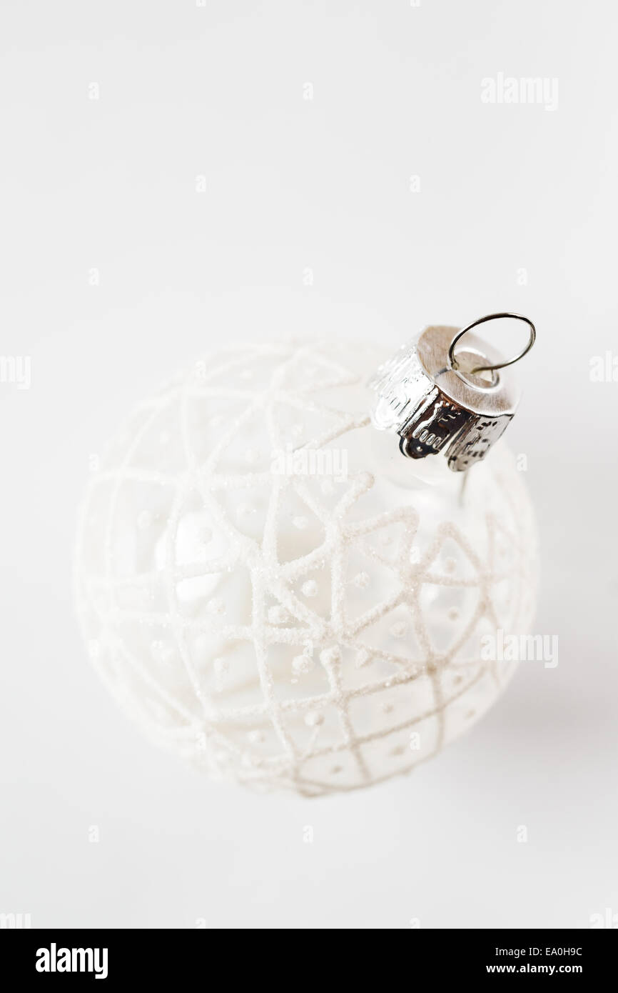 Einfache Weihnachtsdekoration. Weiße Kugel mit verschneiten Ornament auf weißem Hintergrund. Stockfoto