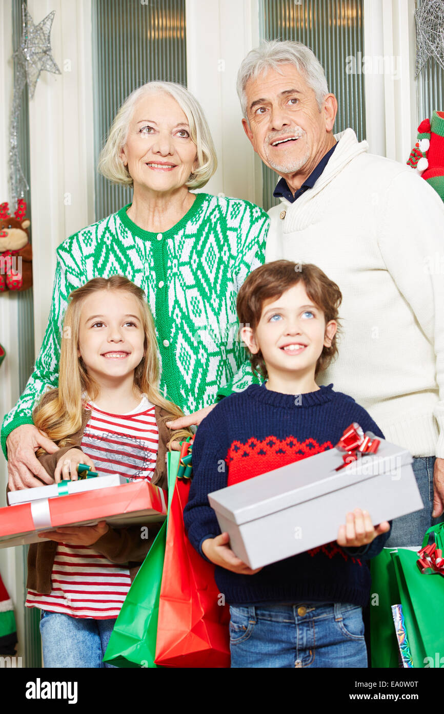 Glückliche Kinder mit Oma und Opa zu Weihnachten Geschenke halten Stockfoto