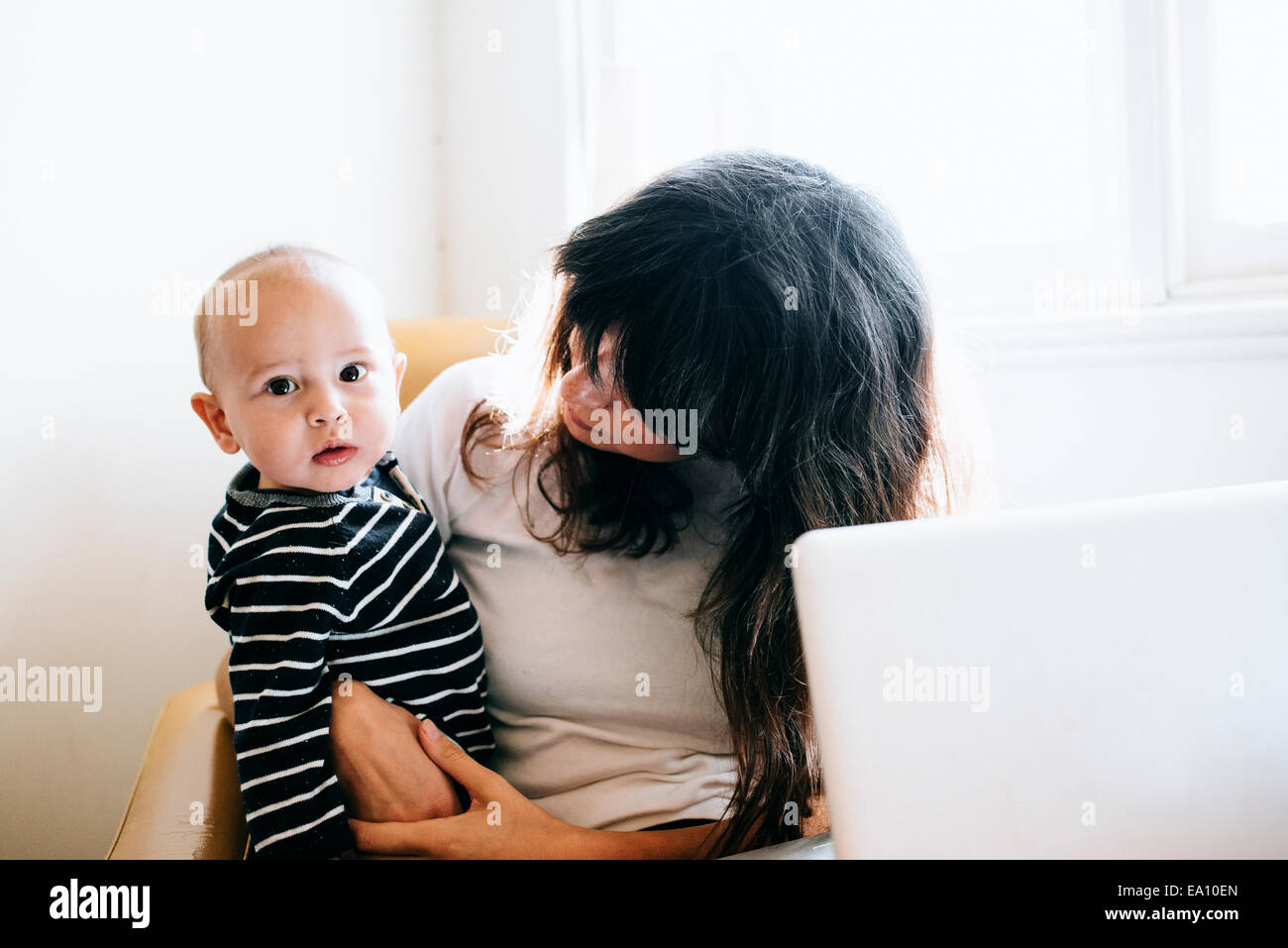 Mutter mit Laptop mit Sohn auf Schoß Stockfoto
