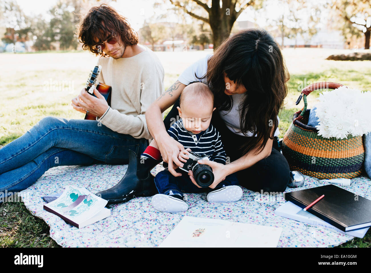 Paar mit Baby auf der Picknickdecke im park Stockfoto