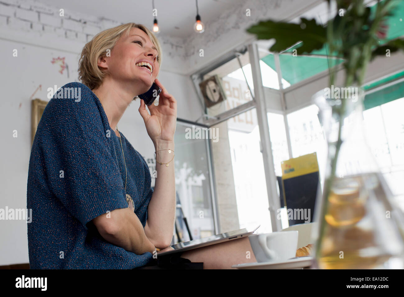 Mitte Erwachsene Frau auf Handy im café Stockfoto