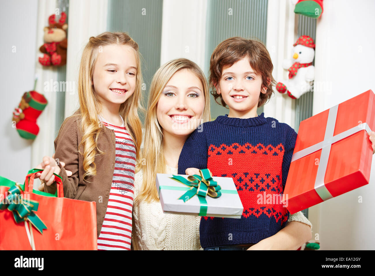 Familie mit jungen und Mädchen, die Opfergabe zu Weihnachten Stockfoto