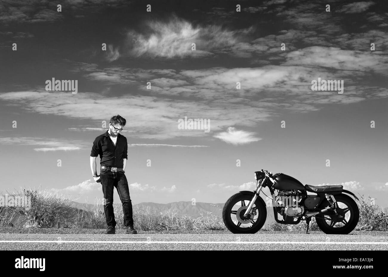 Schwarz-weiß-Porträt von Mitte erwachsenen männlichen Motorradfahrer auf der Autobahn am Straßenrand Stockfoto