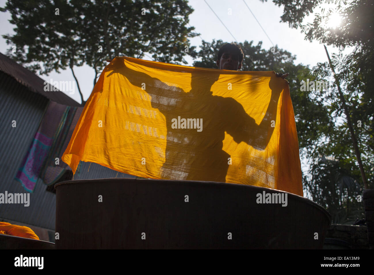 Narayangonj, Bangladesch. 5. November 2014. Menschen sind beschäftigt mit sterbenden roh Tücher vor ihrem Haus. Dorfbewohner in Bangladesch Hand gefärbte Kleidung Geschäfte zu machen. Kleinkredit nehmen sie sammeln, roh Tücher aus Fabrik, nachdem gefärbt sie unter Sonne getrocknet und dann verkaufen sie im Markt und sie sind jetzt stabil. © Zakir Hossain Chowdhury/ZUMA Draht/Alamy Live-Nachrichten Stockfoto