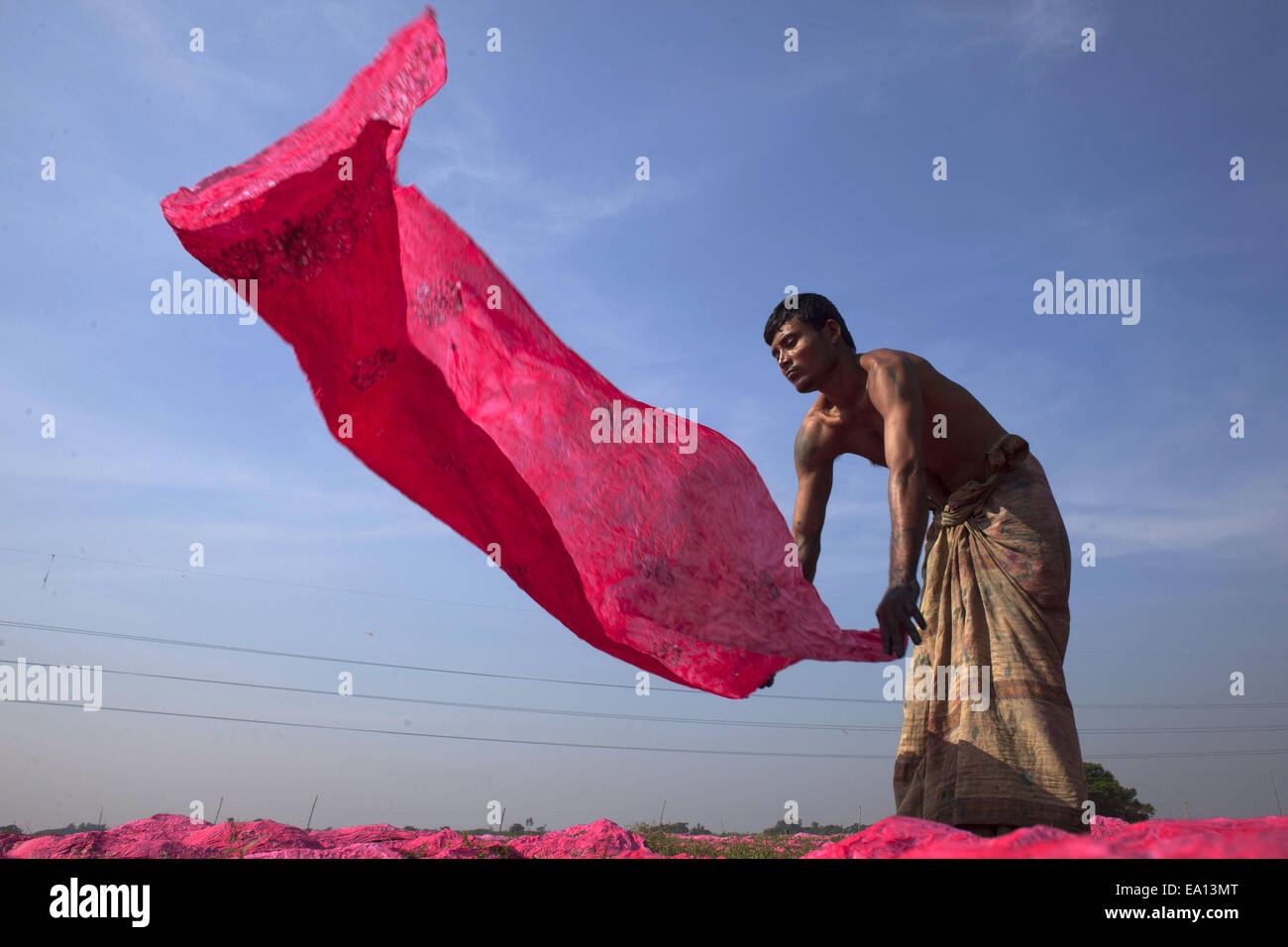 5. November 2014 - Narayangonj, Bangladesch - gefärbt ein Mann trocknen Tücher unter Sonne... Dorfbewohner in Bangladesch Hand gefärbte Kleidung Geschäfte zu machen. Kleinkredit nehmen sie sammeln, roh Tücher aus Fabrik, nachdem gefärbt sie unter Sonne getrocknet und dann verkaufen sie im Markt und sie sind jetzt stabil. (Kredit-Bild: © Zakir Hossain Chowdhury/ZUMA Draht) Stockfoto