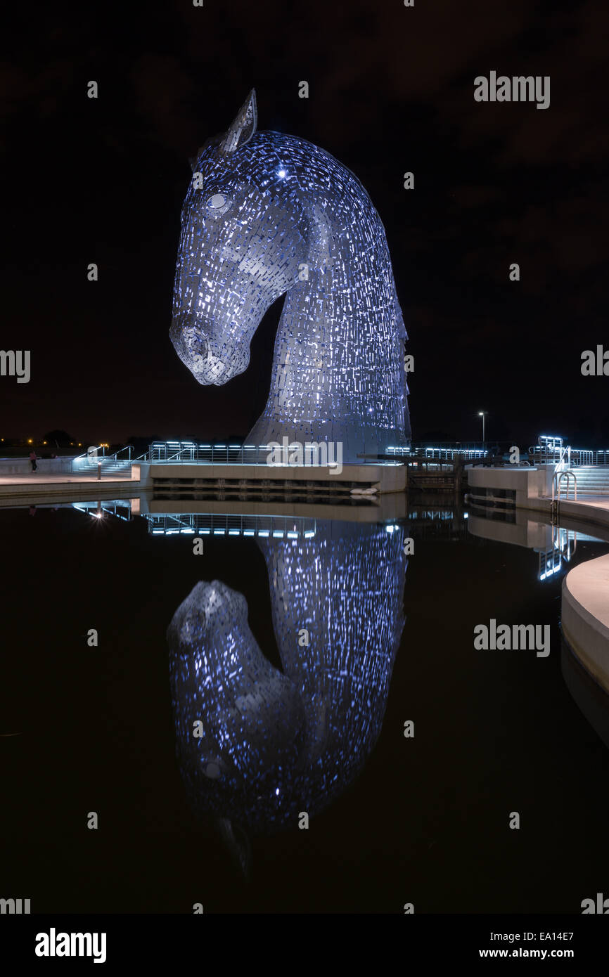 Nachtansicht des Kelpies Pferdeskulptur Denkmal und Reflexion im Teich in Falkirk, Schottland, Großbritannien. Stockfoto