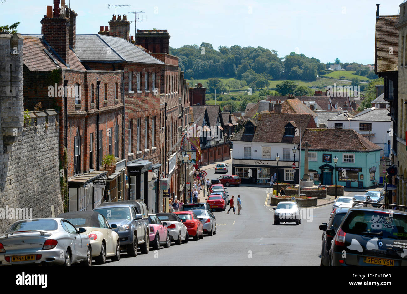 Zeigen Sie auf der hohen Straße in Arundel in West Sussex, England an. Mit geparkten Fahrzeugen und Menschen herumlaufen. Stockfoto