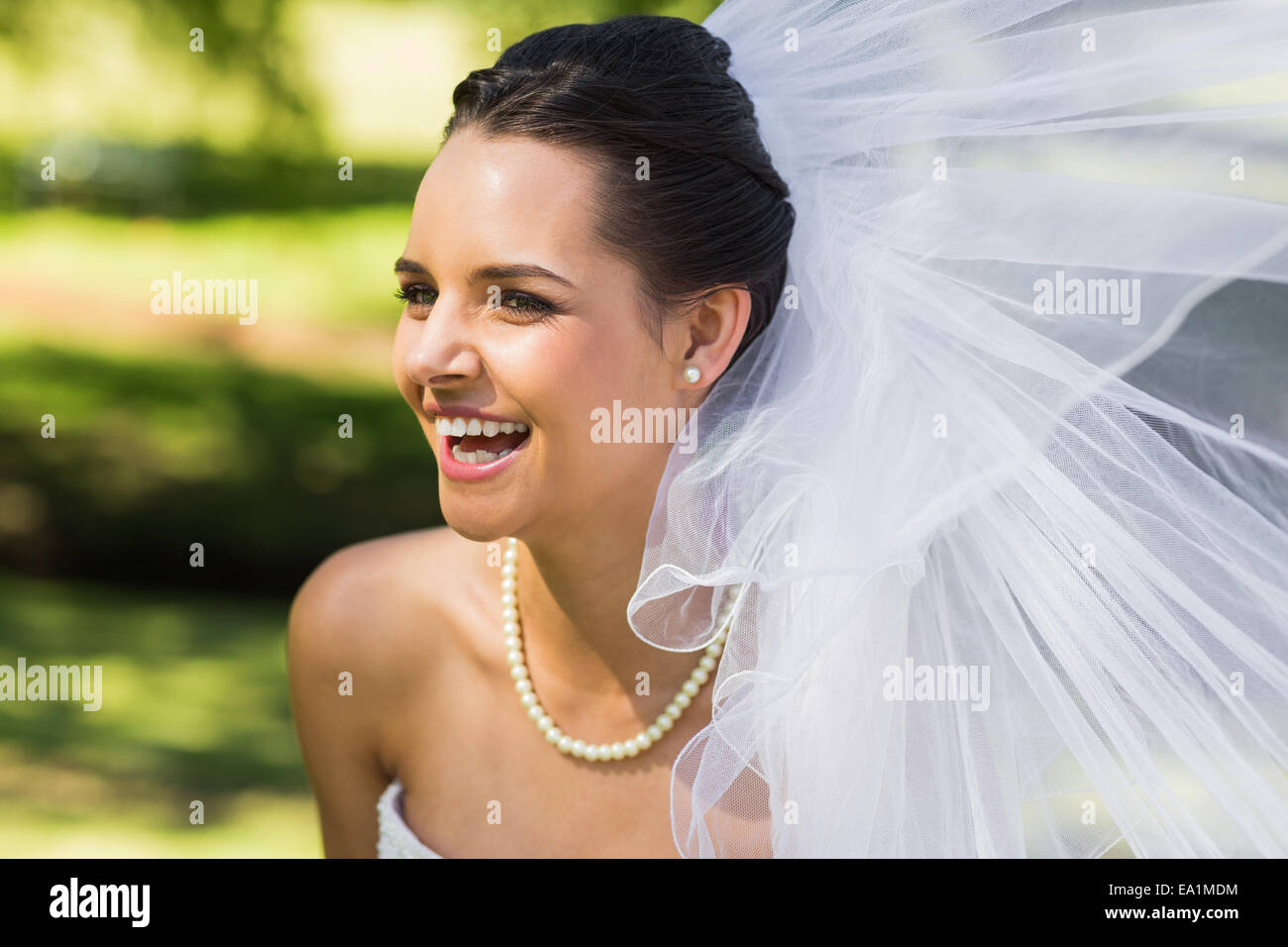Fröhliche junge schöne Braut im park Stockfoto