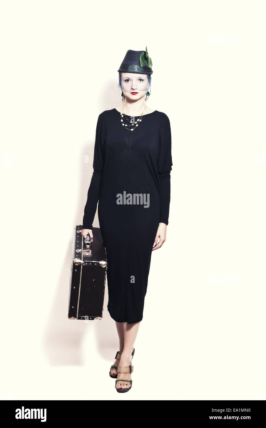 Porträt der jungen Frau mit Koffer. Retro-Stil Stockfoto