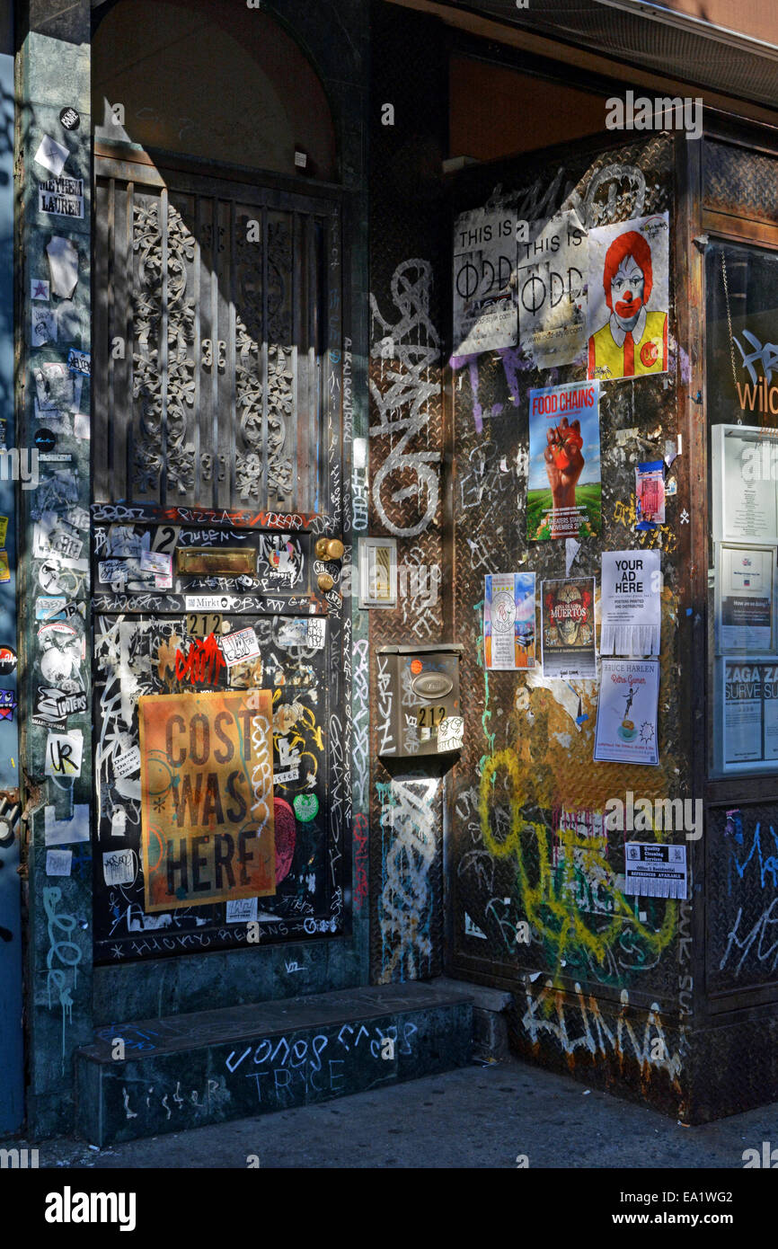 Schatten und Licht Muster auf ein Tor mit Graffiti und zerrissenen Plakaten in Willimsburg, Brooklyn, New York Stockfoto