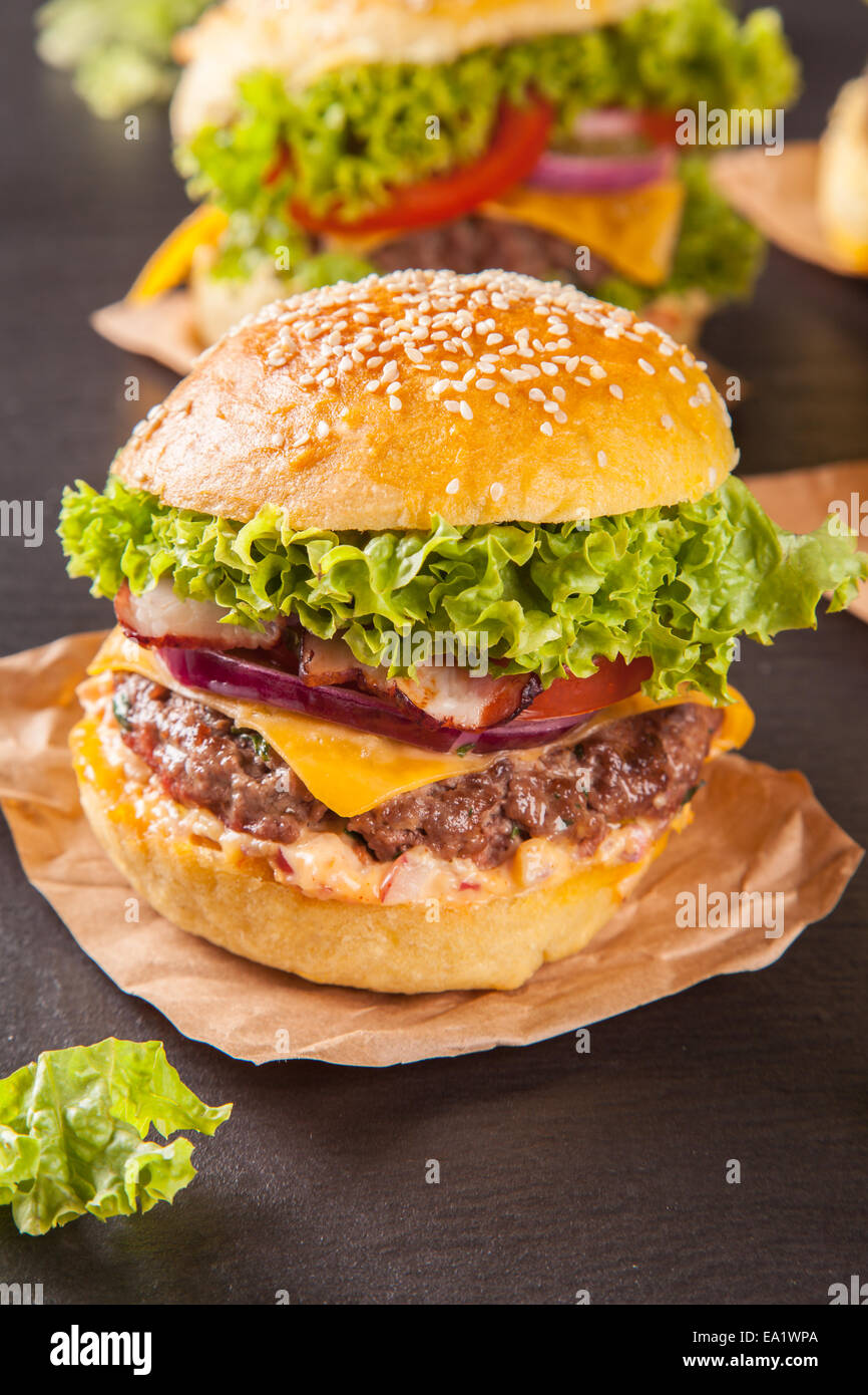 Leckere hausgemachte Hamburger serviert auf schwarzem Stein Stockfoto