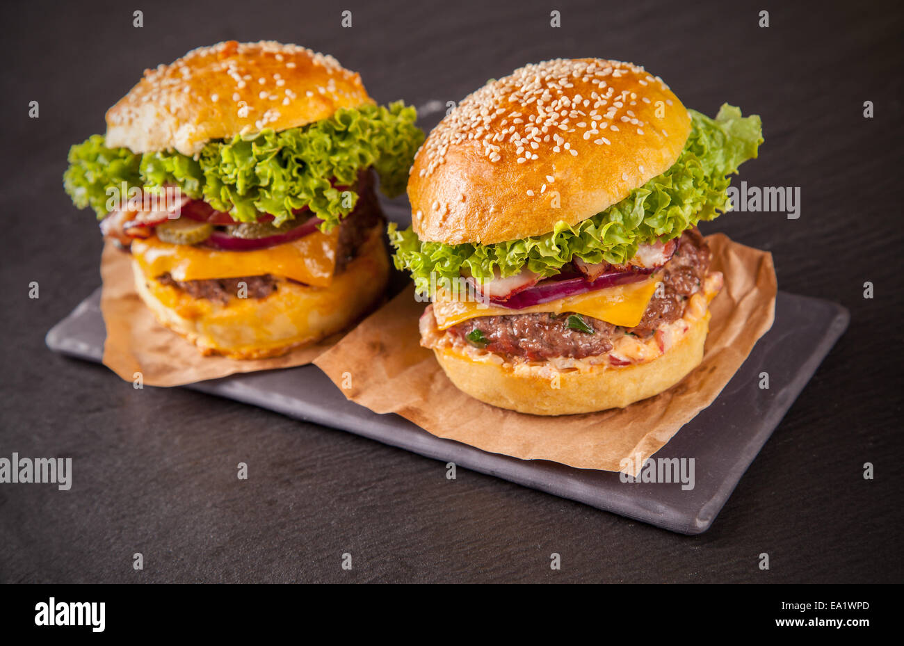 Leckere hausgemachte Hamburger serviert auf schwarzem Stein Stockfoto