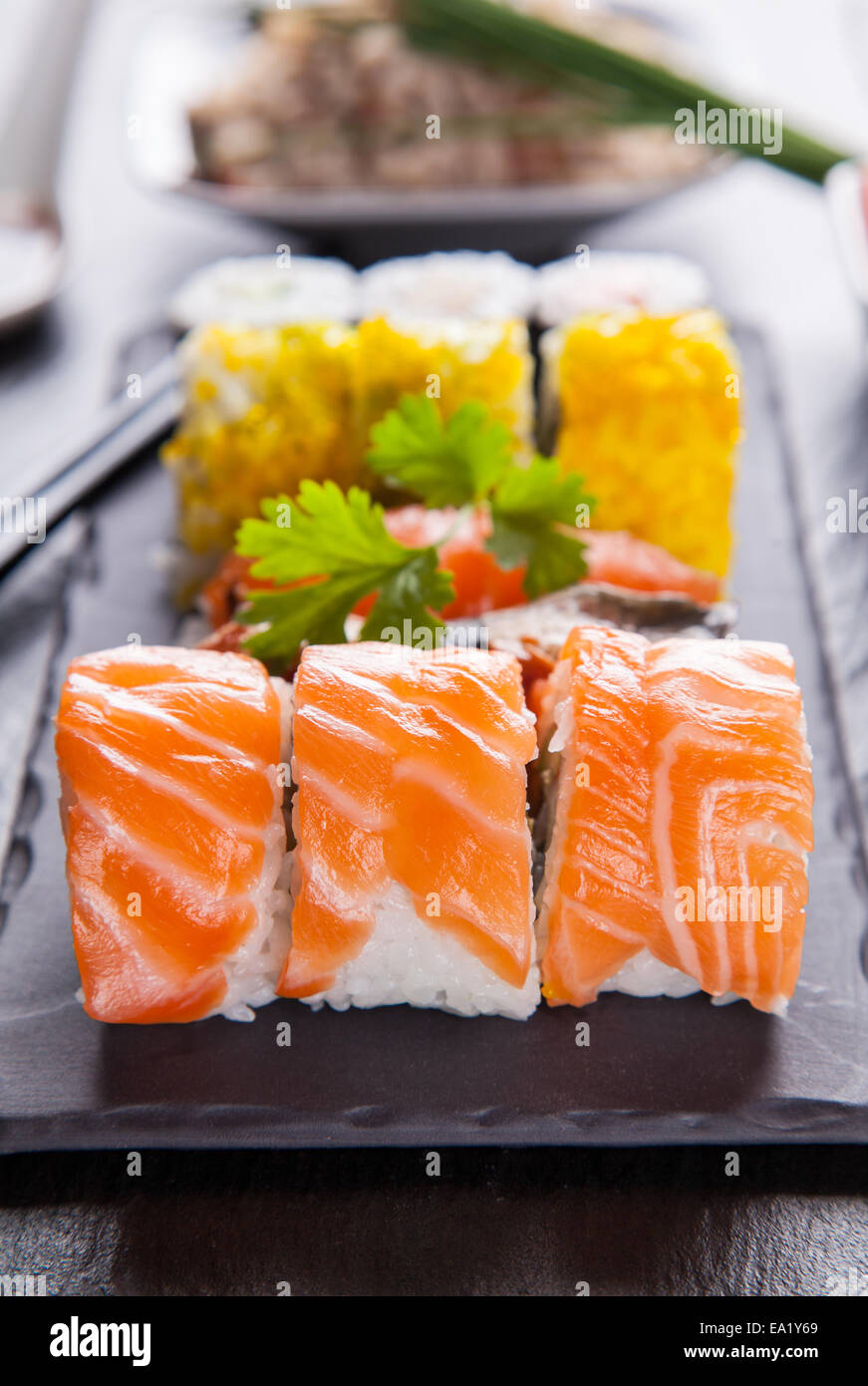 Verschiedene Arten von Sushi Essen serviert auf schwarzem Stein Stockfoto