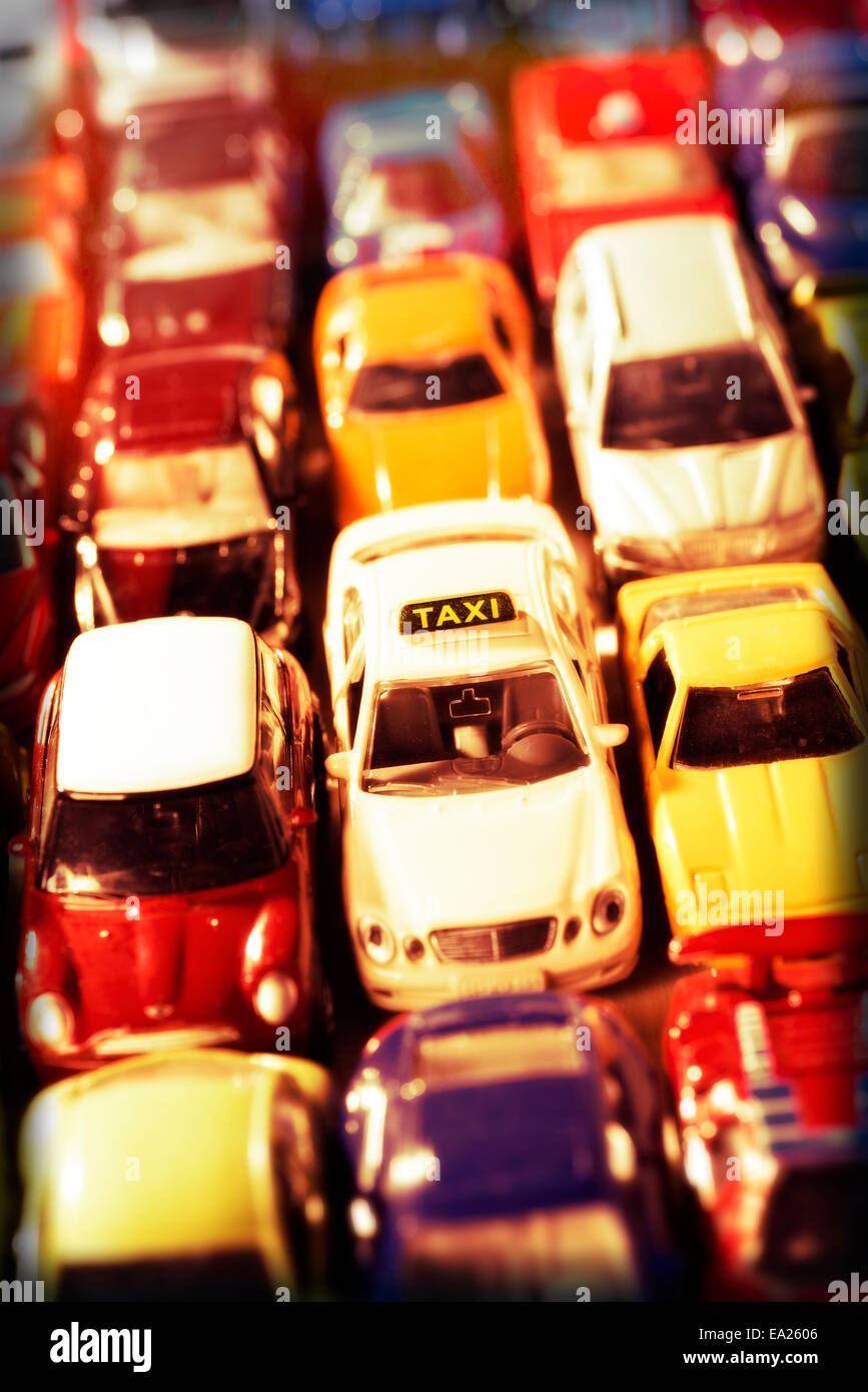 Ein Taxi ist umgeben von vielen anderen Autos, als Symbol für die zunehmende Konkurrenz durch neue Wettbewerber. Stockfoto