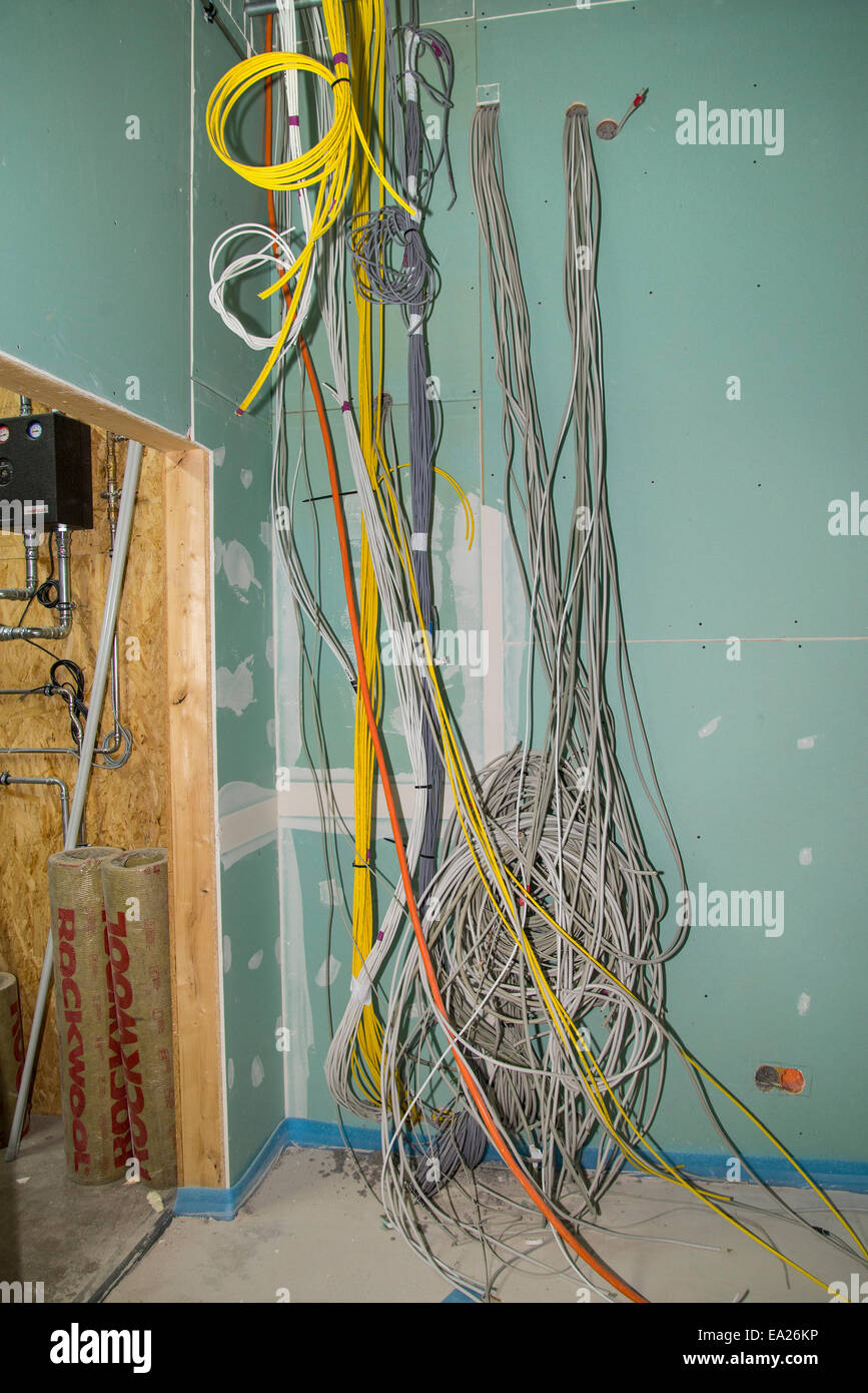 Kabel und Netzwerk Kabel an der Wand im Inneren eines Mehrfamilienhauses im Bau. Stockfoto