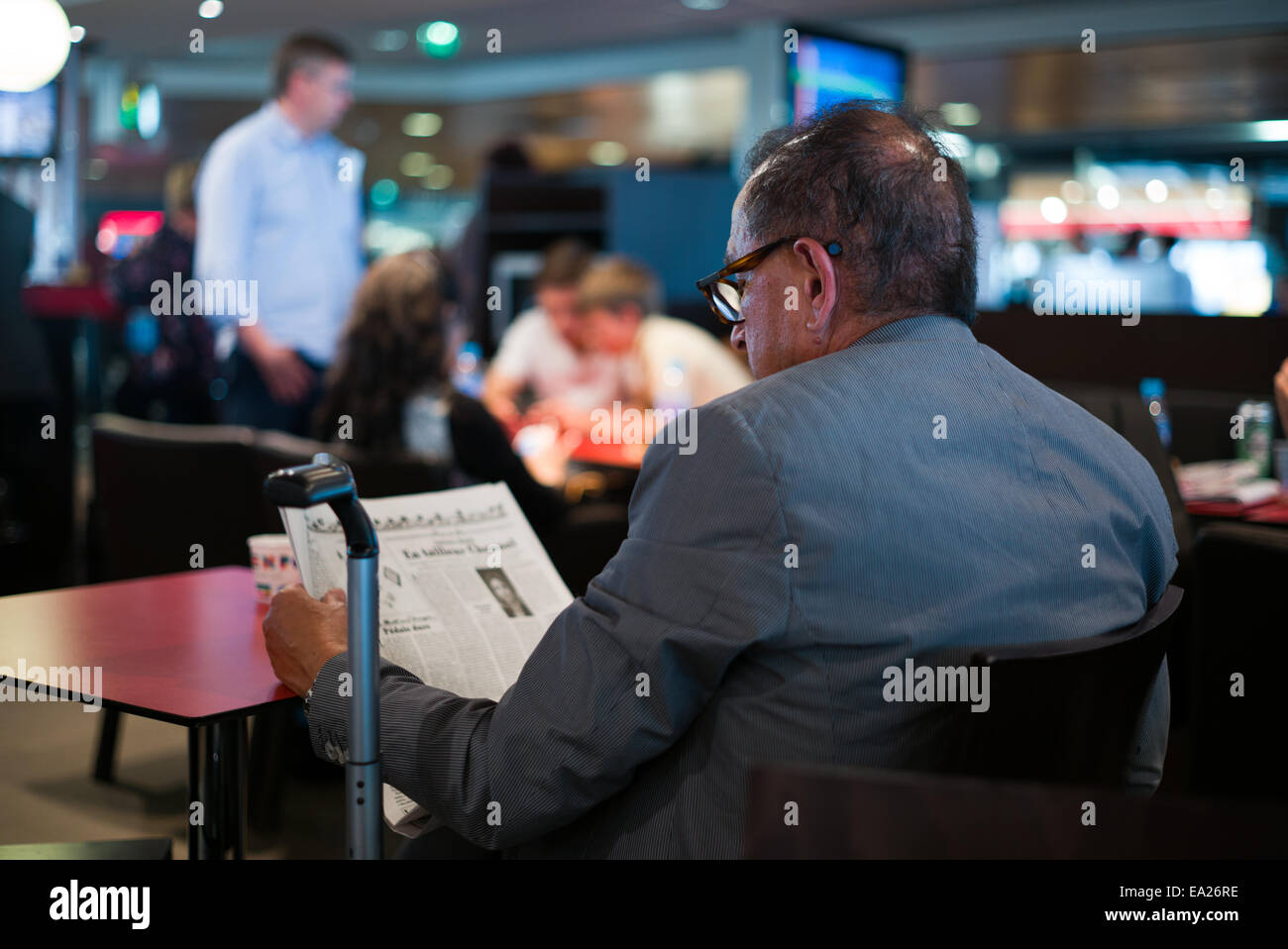 Alte Mann liest französische Zeitung am Flughafen Orly, Frankreich. Stockfoto