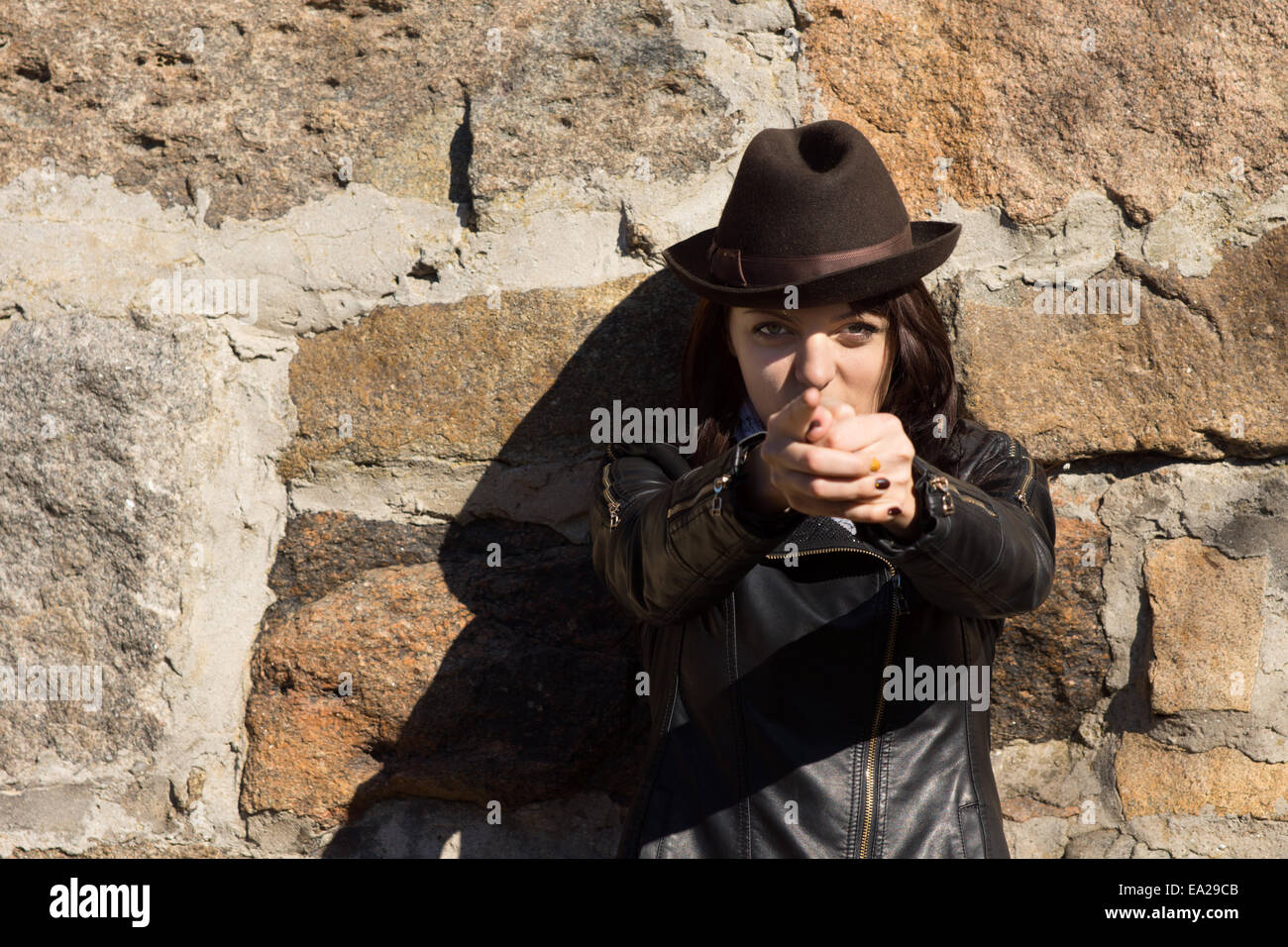 Frau Hut machen Pistole mit Händen und in Richtung Kamera Stockfoto