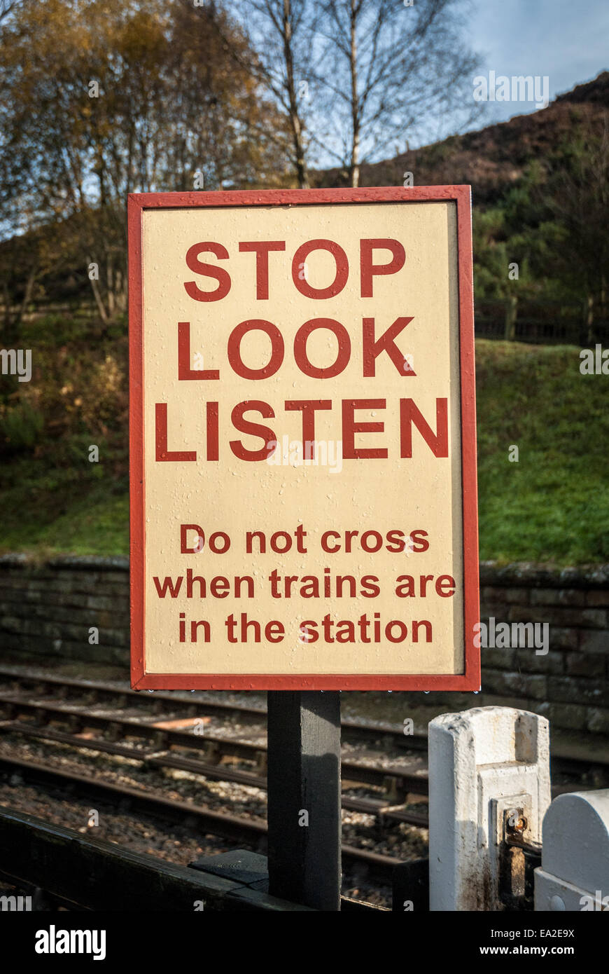 Eine Eisenbahn Fußgängerüberweg Zeichen Warnung bei einem alten Bahnhof in Goathland, England. Stockfoto