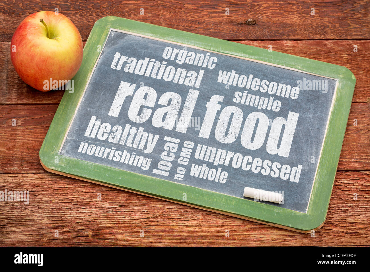 richtiges Essen Wortwolke auf einer Tafel mit einem Apfel - gesunde Lifestyle-Konzept Stockfoto