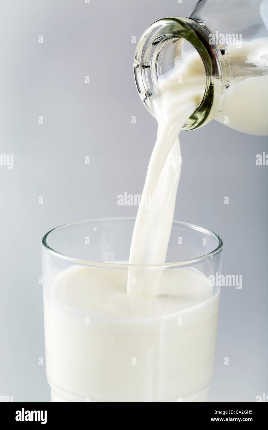 Glasflasche Milch in Glas mit weißem Hintergrund; Calgary, Alberta, Kanada Stockfoto