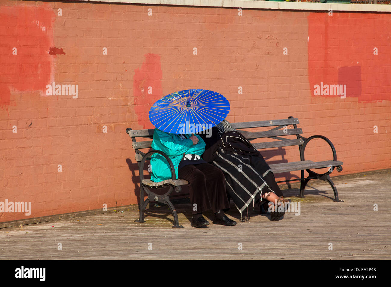 Ein paar sitzt am Boardwalk, Brighton Beach, Brooklyn, New York, Vereinigte Staaten von Amerika Stockfoto