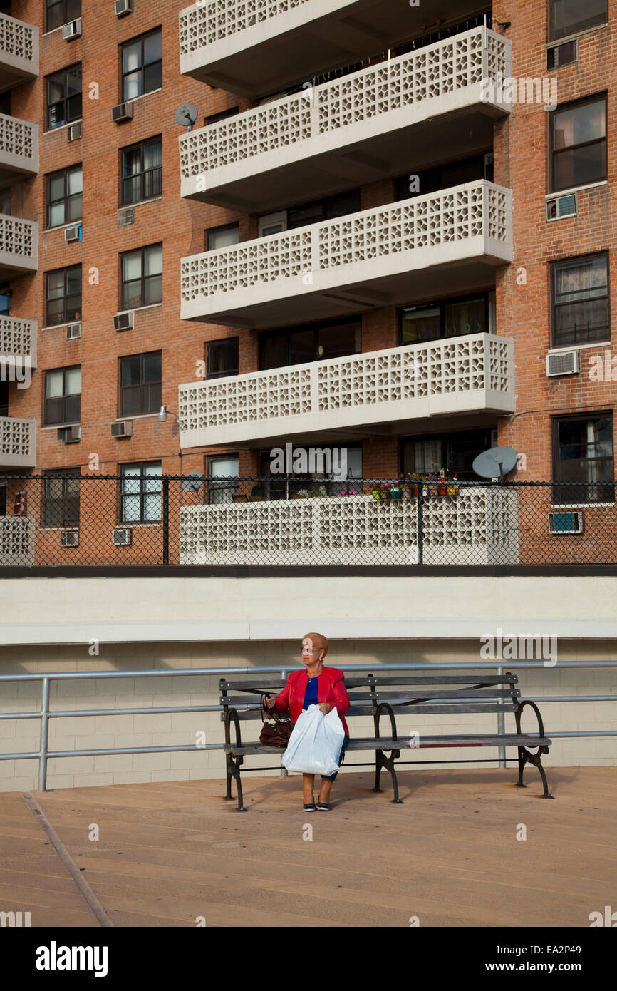 Eine Frau sitzt am Boardwalk, Brighton Beach, Brooklyn, New York, Vereinigte Staaten von Amerika Stockfoto