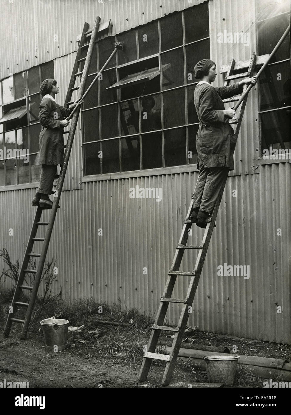 Dieses Foto zeigt Frauen, die Fenster reinigen und einen Moment des Alltags festhalten. Die Szene zeigt die Arbeitsbedingungen und Aufgaben von Frauen und bietet einen Einblick in ihre Rolle in der Gesellschaft und im Arbeitsleben. Das Bild konzentriert sich auf die routinemäßige, aber dennoch wichtige Arbeit der Fensterreinigung. Stockfoto